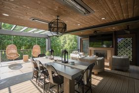 covered deck with tv and fireplace wall