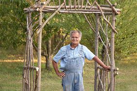 man with finished willow arbor