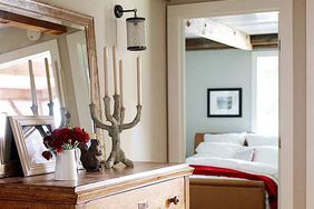 dresser with mirror above room with wood beams