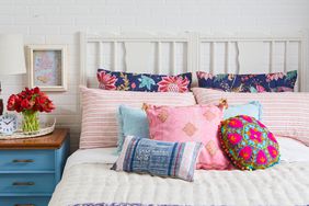 blue and pink throw pillows on bed with blue nightstand