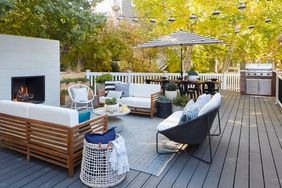 a deck with seating around it and a fireplace