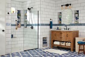 bathroom with walk-in shower with white tile and blue floor tiles