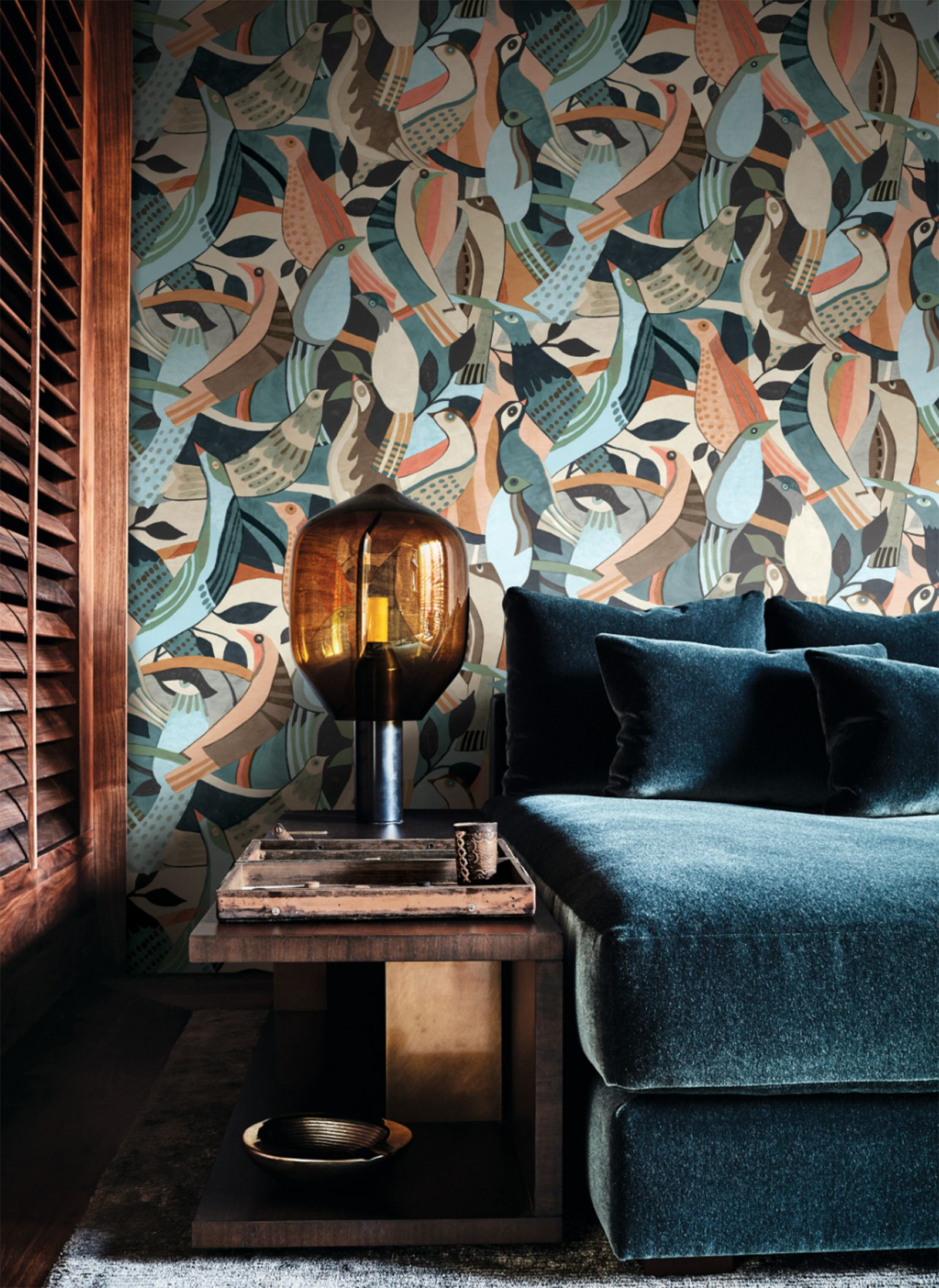 bird wallpaper print with dark blue couch