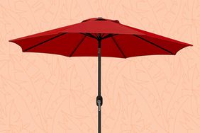 A red patio umbrella over a peach patterned background.