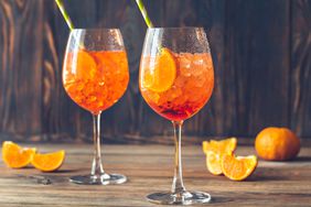 two wine glasses with aperol spritz cocktail and orange slices
