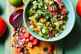 Avocado-Poblano Salsa in bowl with peppers, onions, and tomatoes on cutting board