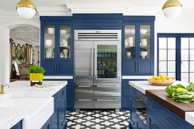 stainless steel refrigerator in traditional kitchen with blue cabinets