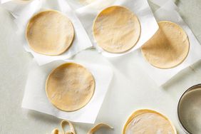 round handmade dumpling wrappers overhead on parchment paper