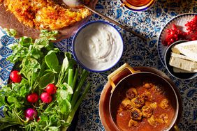 traditional Iranian meal of Fesenjan, a rich walnut and meat stew, crispy rice, yogurt and feta