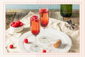Two Kir Royales in champagne glasses with berries