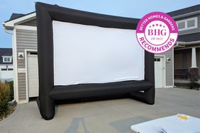 Outdoor movie screen stands in front of garage doors