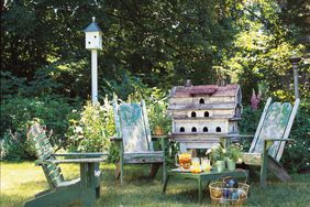 Outdoor seating area in garden with birdhouses and table