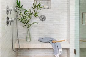 White tile shower with towel on bench