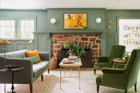 sitting room with a green and brick fireplace and green furniture