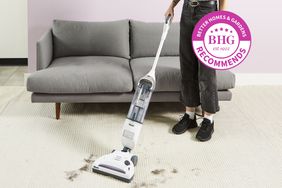A person removes hair from the carpet using Shark Navigator Freestyle Cordless Upright Vacuum