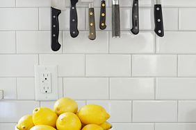 bowls of lemon on counter in front of light socket and knives