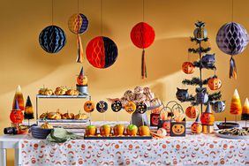 Retro-inspired Halloween party layout on table with decor and snacks