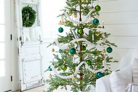 Christmas tree next to white sofa with gifts