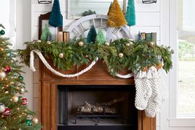 garland-covered mantel with knit Christmas stockings and trees