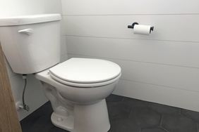 white toilet in bathroom with shiplap walls