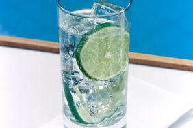 Glass of sparkling water with ice cubes and a slice of lime seltzer health effects