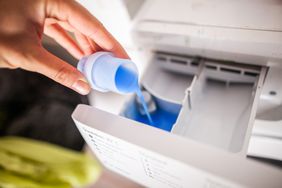 pouring liquid detergent into a washing machine