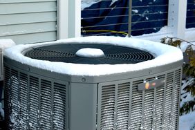 house hvac air conditioner outside with snow in the winter