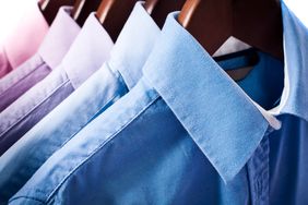 collared button-down shirts on wood hangers dry cleaning