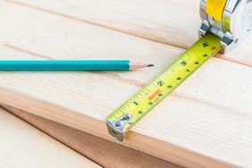 tape measure or measuring tape and pencil on wood boards