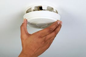 hand installing smoke detector