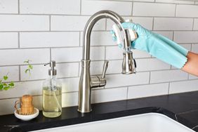 scrubbing kitchen sink faucet with sponge 