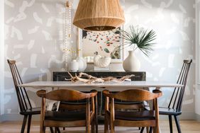 Neutral dining room with wooden chairs and lighting fixture