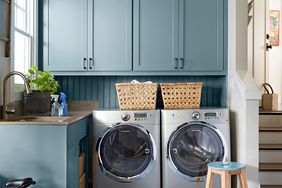 laundry room with stool and muted blue cabinets