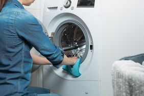 person wiping down dryer with blue cloth to remove ink