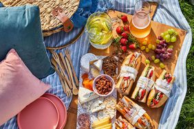 picnic with sandwiches, charcuterie, and pink plates
