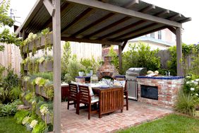 Outdoor pergola and brick kitchen with a dining table
