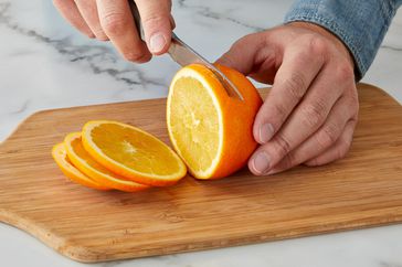 slicing oranges on cutting board