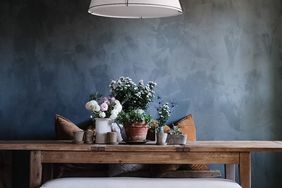 dark color washed walls with styled flowers on a wooden table