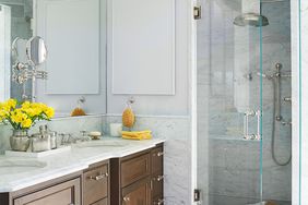 walk in shower with marble tiles and wooden vanity
